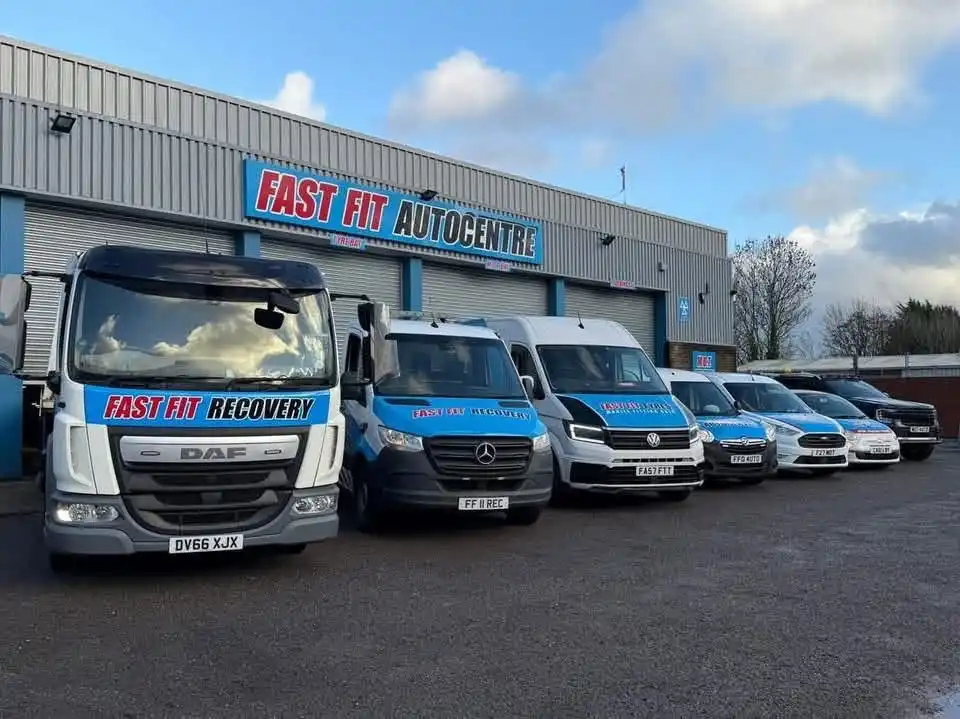 Fast Fit Recovery DAF truck and recovery vans lined up outside the Fast Fit Autocentre building